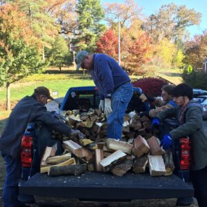 Men unloading firewood from truck
